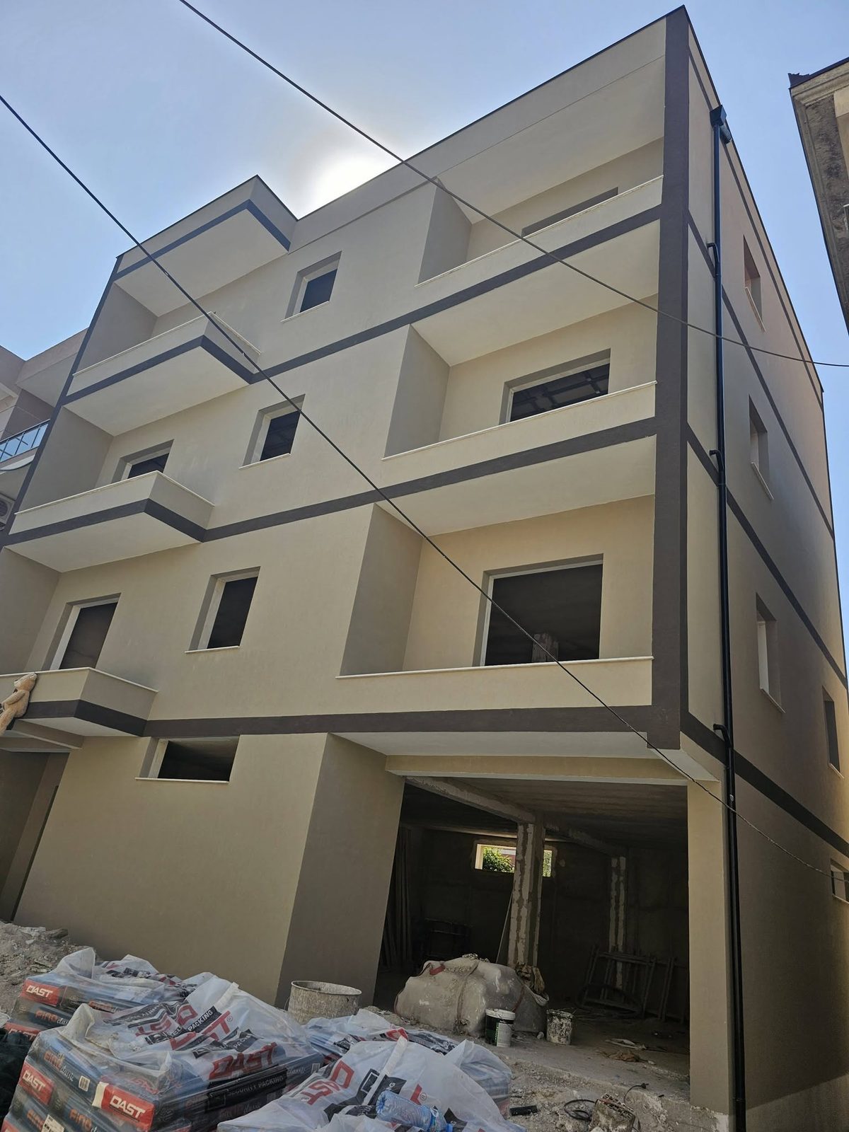 Pallat katërkatësh me fasadë krem dhe shirita gri